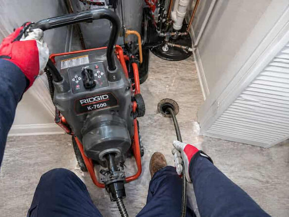 Main Line Drain Cleaning and Clog Removal A motorized professional drain snake clearing a main sewer line in a Columbus suburban home.